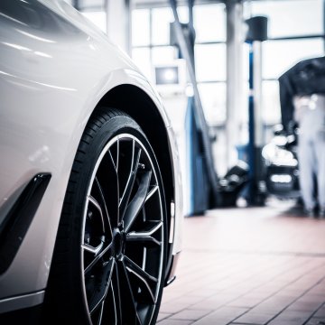 axiom extended car warranty moxa vehicle service contracts review overview car in repair shop mechanic working on a car in the background